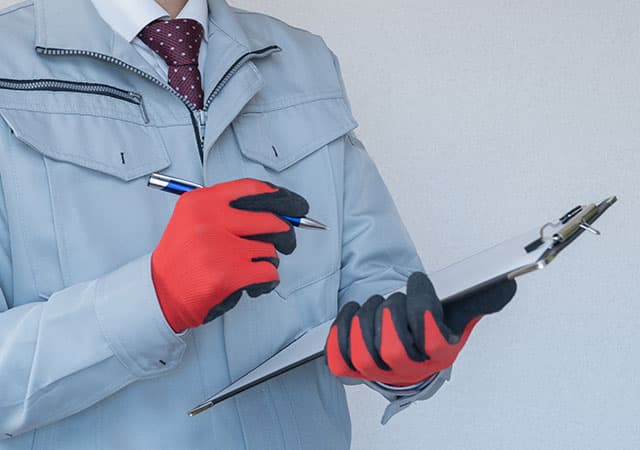 チェックする作業服姿の男性のイメージ